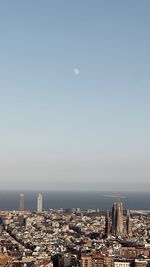 High angle view of townscape by sea against clear sky