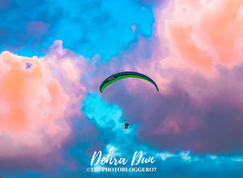 Low angle view of person paragliding against sky