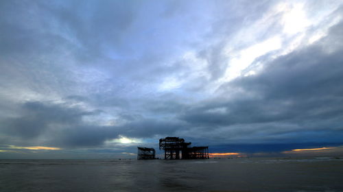 Boat sailing on sea against dramatic sky