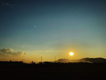 Scenic view of silhouette field against sky during sunset