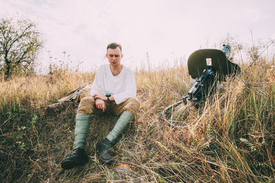 Full length of man sitting on field