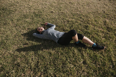 High angle view of woman sitting on grassy field