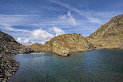 Scenic view of sea and mountains against sky