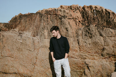 Full length of man standing on cliff against clear sky