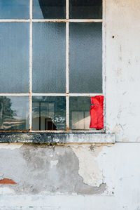Red window on white wall by building