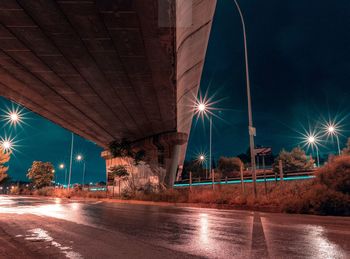 Light trails on street against sky at night
