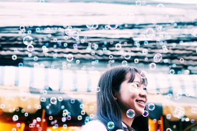 Portrait of a smiling young woman at bubbles