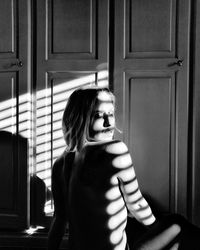 Cute girl standing at entrance of home