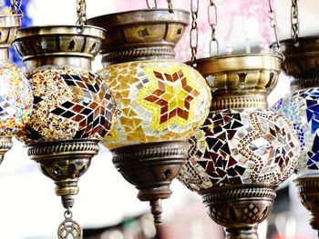 Close-up of ornate decorations hanging on metal structure