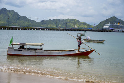 Fishing boat in sea against sky