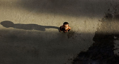 High angle view of smiling shirtless boy standing on road