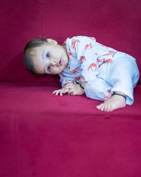 Portrait of cute baby boy lying on floor at home