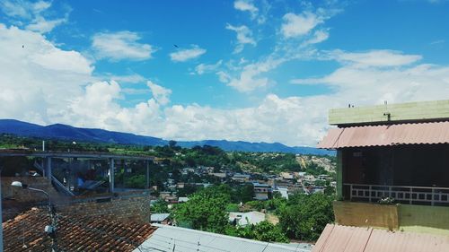 Buildings in town against cloudy sky