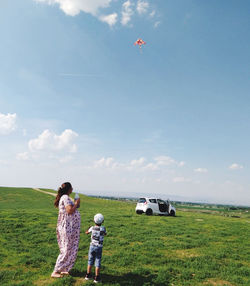 People standing on field against sky