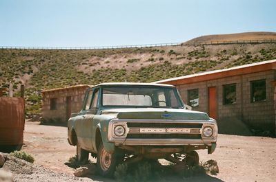 Abandoned car on land against clear sky