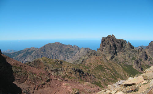 Scenic view of mountains against clear blue sky