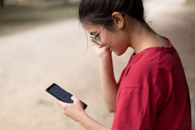 Side view of woman using mobile phone