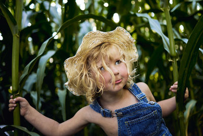 Portrait of cute girl with plants in background