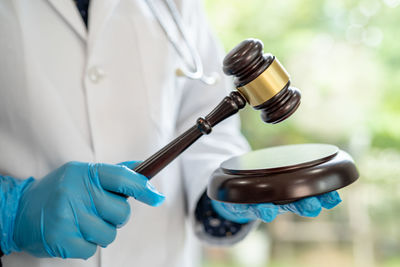 Midsection of doctor holding laboratory equipment