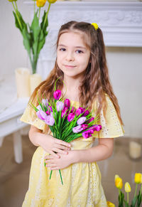 Portrait of young woman holding flower bouquet
