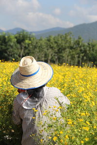 Rear view of person wearing hat on field