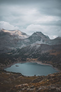 Scenic view of lake by mountains against sky