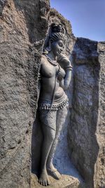 Low angle view of female statue against rock formation