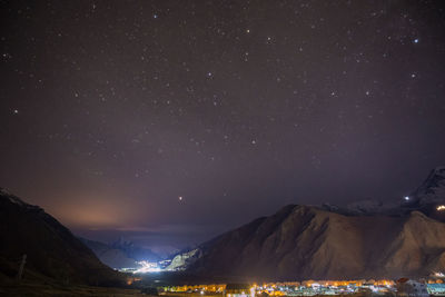 Scenic view of illuminated mountains against sky at night