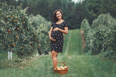 Portrait of smiling young woman standing on field