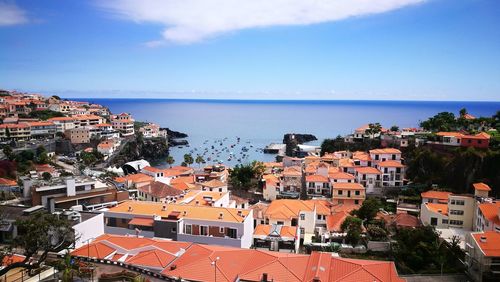 High angle view of townscape by sea against sky