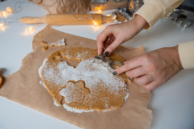 Making christmas gingerbread cookies from dough, holding a mold with your hands