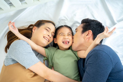 Rear view of father and son on bed