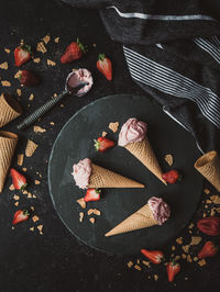 Top view of strawberry ice cream cones on a black background.