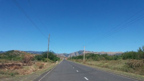 Road against clear blue sky