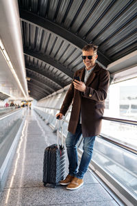 Man leaning on railing at airport