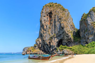 Panoramic view of rock formation in sea against clear blue sky