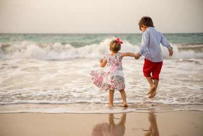 Rear view of children on beach