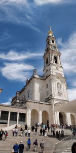 Group of people outside cathedral against sky