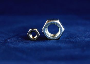 Close-up of steel nuts on blue background