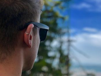 Close-up of man wearing sunglasses against sky