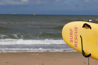Information sign on beach against sky