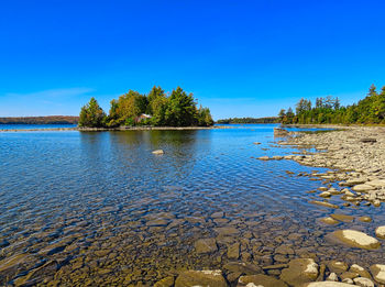 Scenic view of lake against clear blue sky