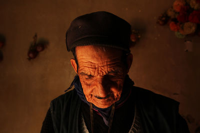 Close-up of senior man looking down against wall