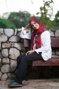 Young woman sitting on bench at park