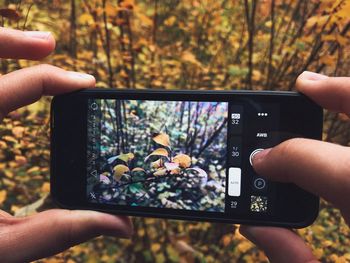 Midsection of person photographing with mobile phone