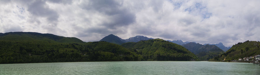 Scenic view of river and mountains against sky