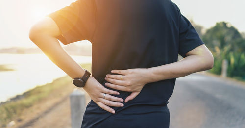 Midsection of man standing against wall