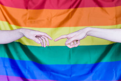 Cropped image of hands gesturing against colorful fabric