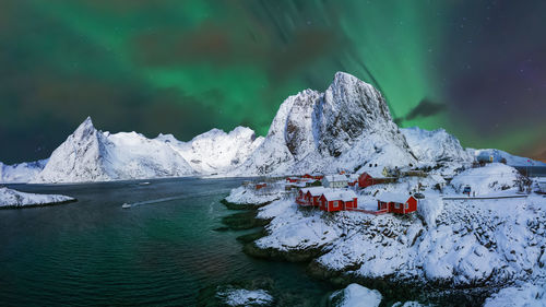 Scenic view of snowcapped mountain by sea against sky