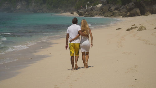 Beautiful couple embracing walking along the beach. relationships, 